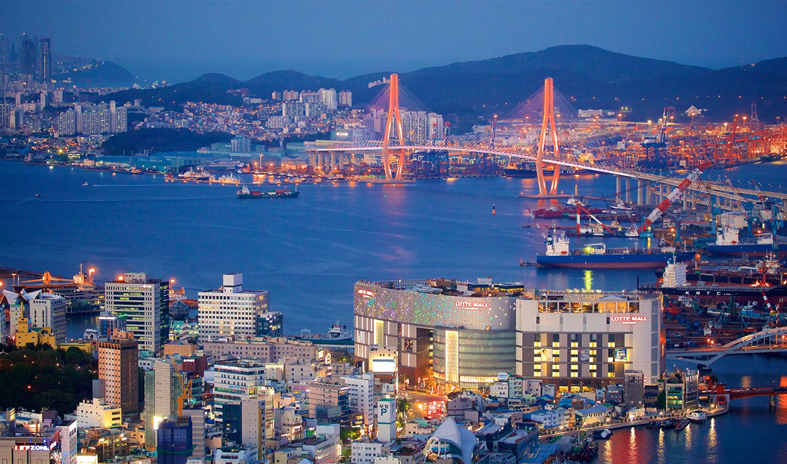 Imagem de busan com prédios, rio e ponte